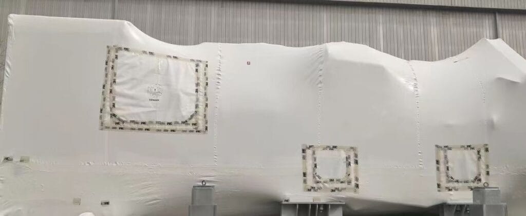 GreenVCI Shrink Film applied to large heavy machinery for corrosion protection, white VCI shrink wrap tightly conforming to irregular industrial equipment in factory storage, preventing rust during long-term preservation.